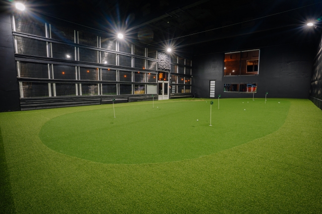 Plaša iekštelpu golfa zāle ar profesionālu ripināšanas grīnu