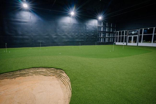 Ripināšanas grīns telpās ar smilšu bunkuru priekšplānā