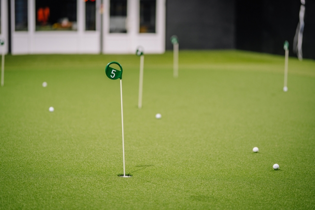 Golfa ripināšanas grīna bedrīte ar karodziņu un bumbiņām